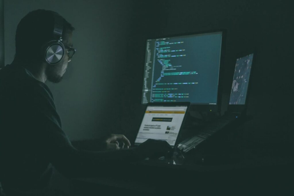Software engineer working across multiple computer screens
